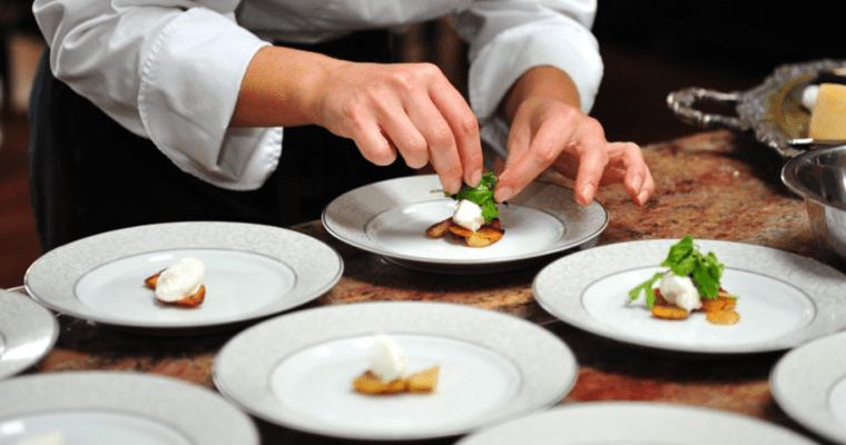 A chef is preparing a plate of food.