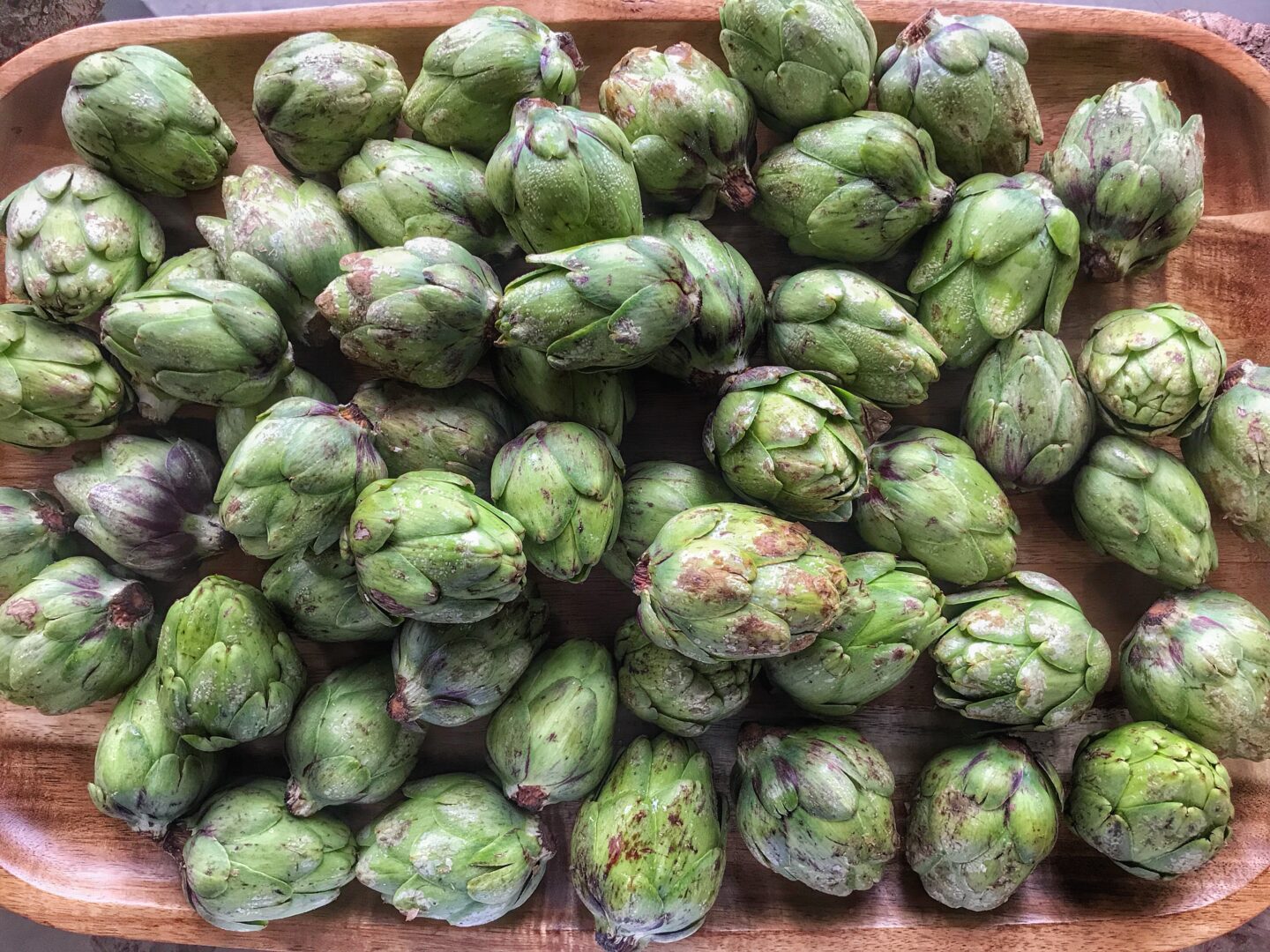 Artichokes on a wooden tray.