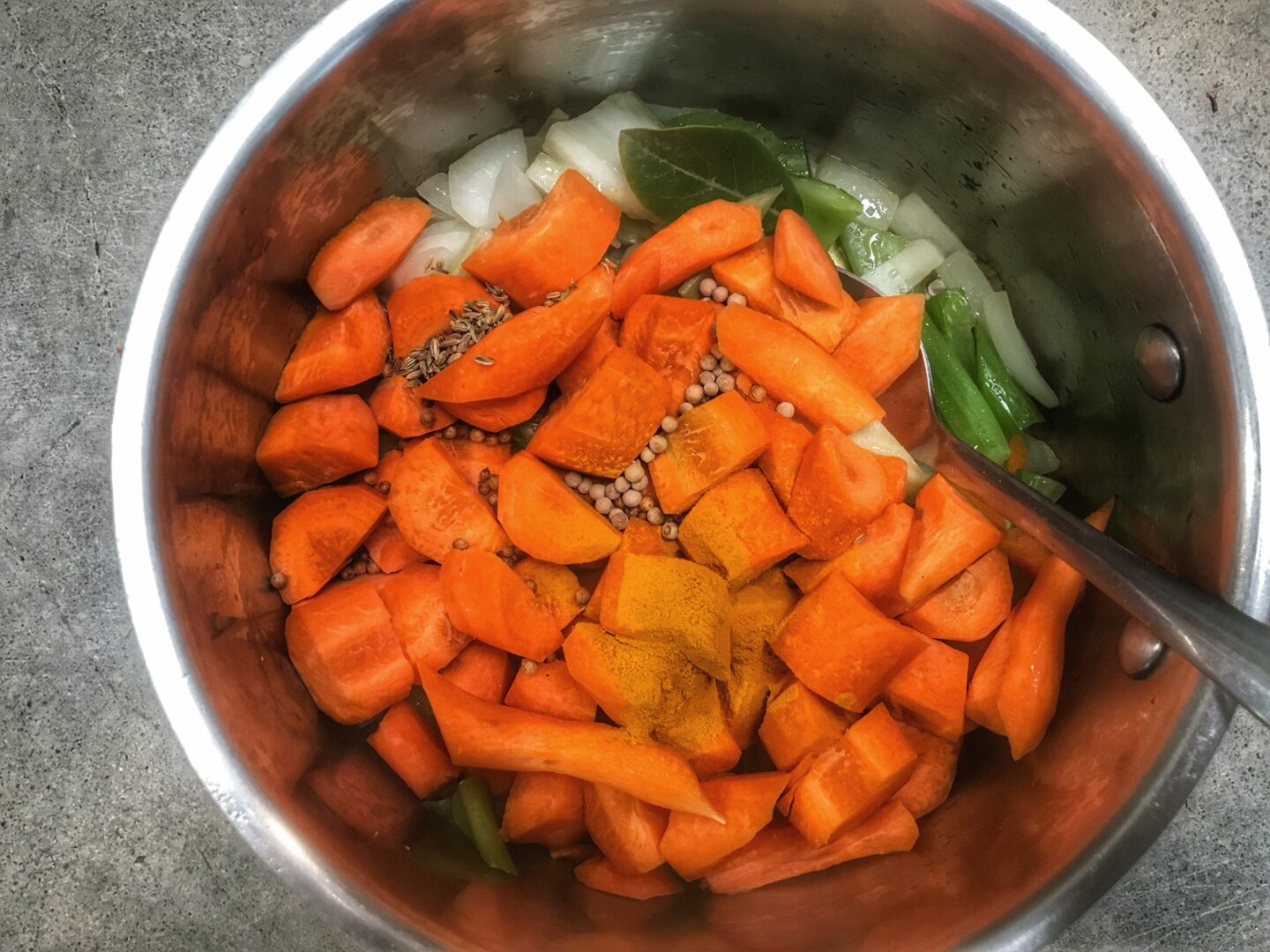 Carrots in a pot with a spoon.