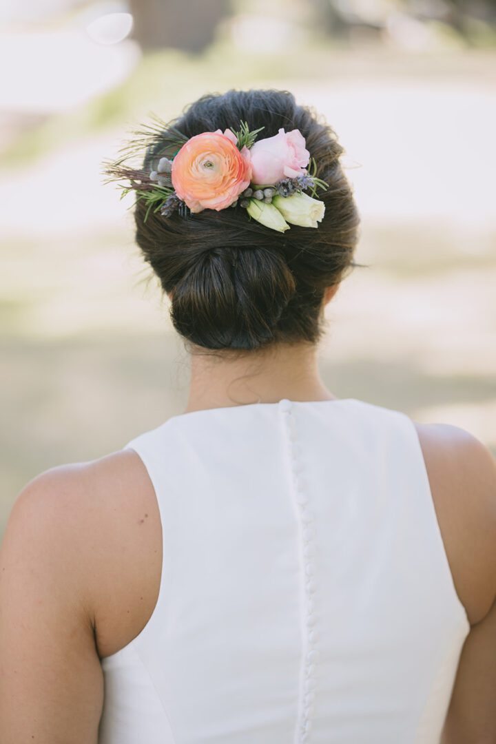 A bride in a white dress with a flower in her hair.