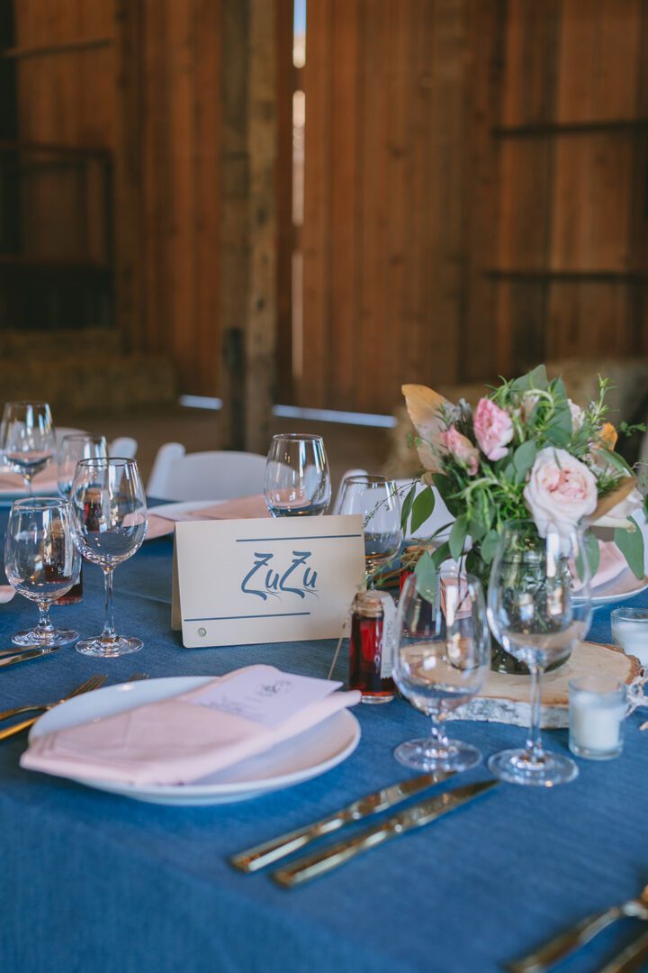 A table setting with blue linens and flowers.