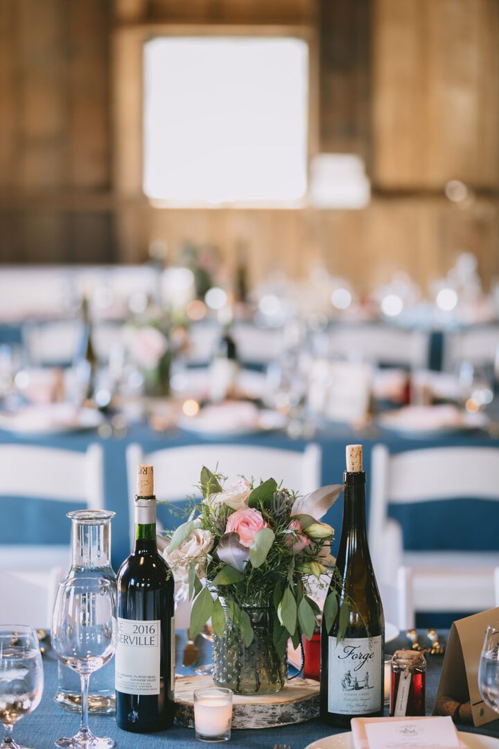 A blue table setting with wine bottles and wine glasses.
