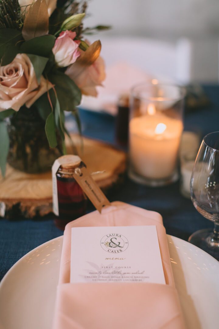 A table setting with a pink napkin and flowers.