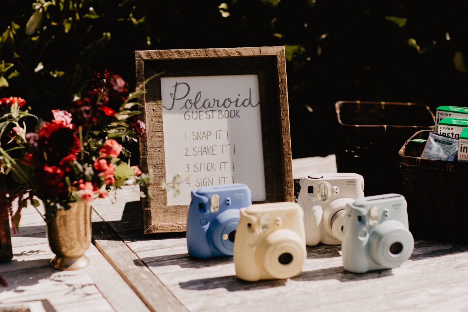 A table with several vintage cameras and a sign.