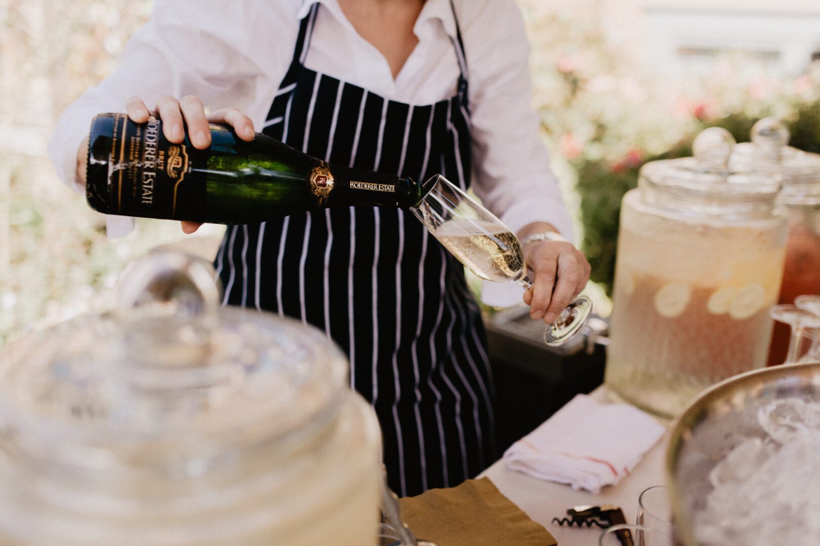 A woman pouring champagne into a glass.