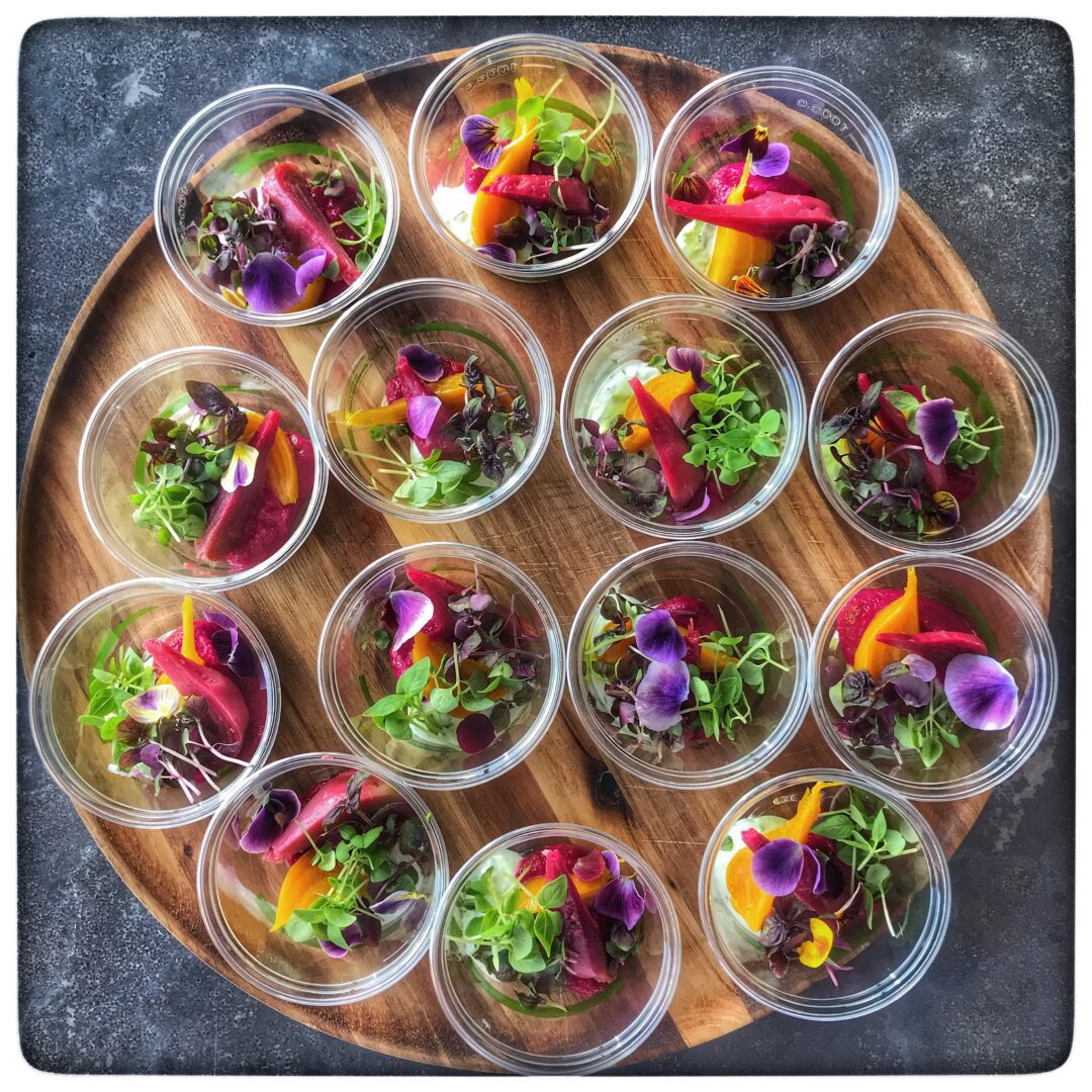 A tray of small bowls filled with vegetables and herbs.