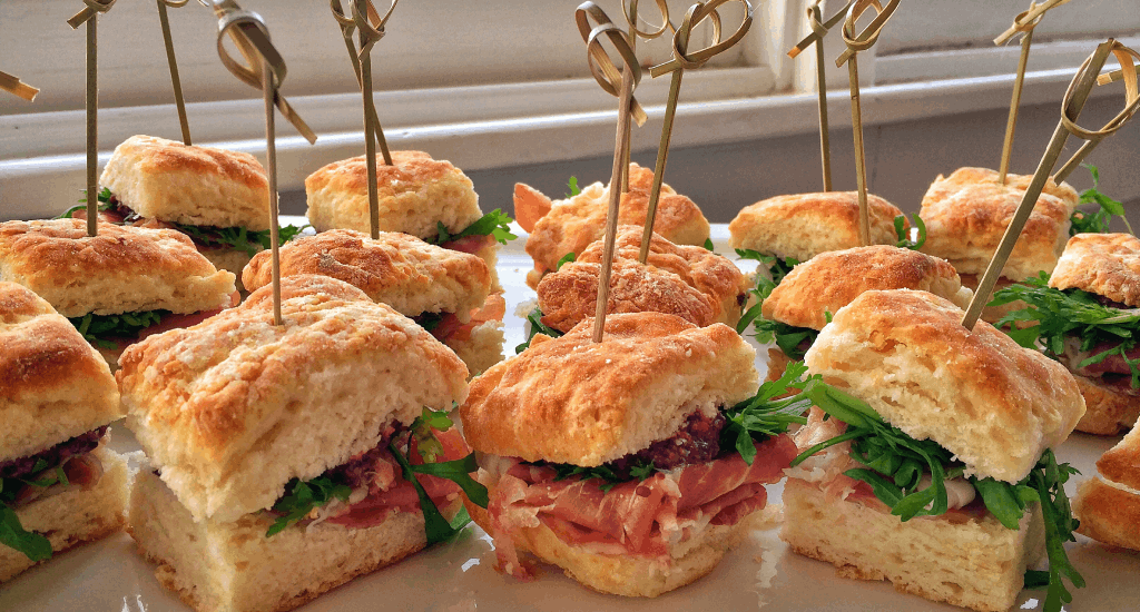 A plate of sandwiches with toothpicks on them.