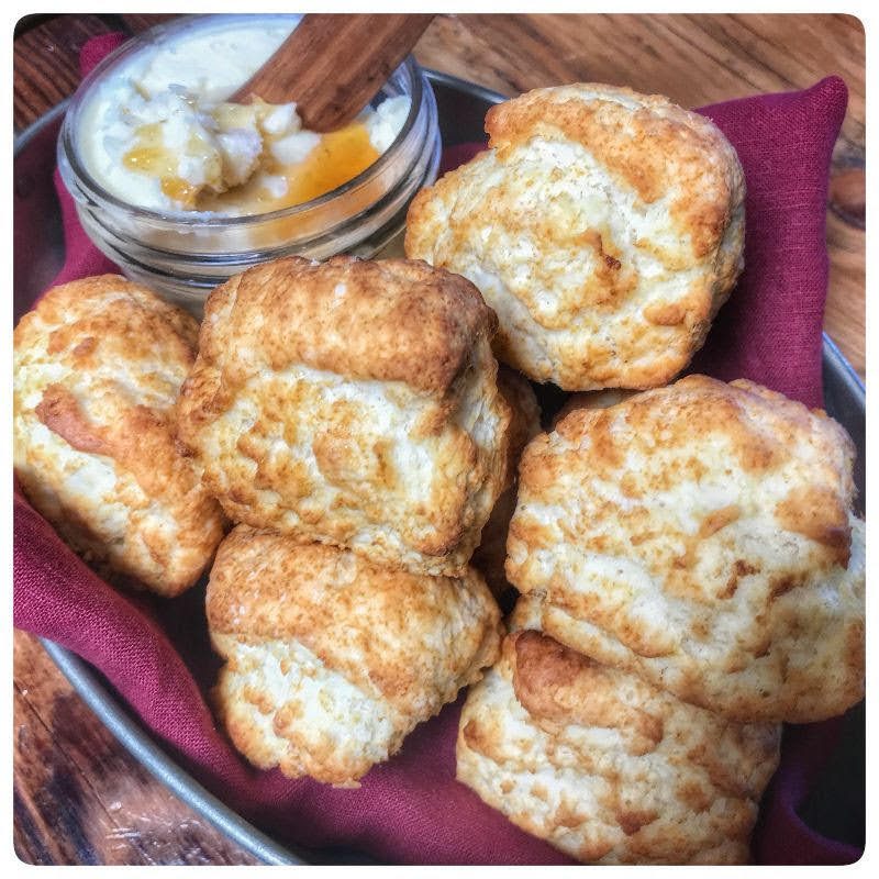 A plate of biscuits with a bowl of dipping sauce.