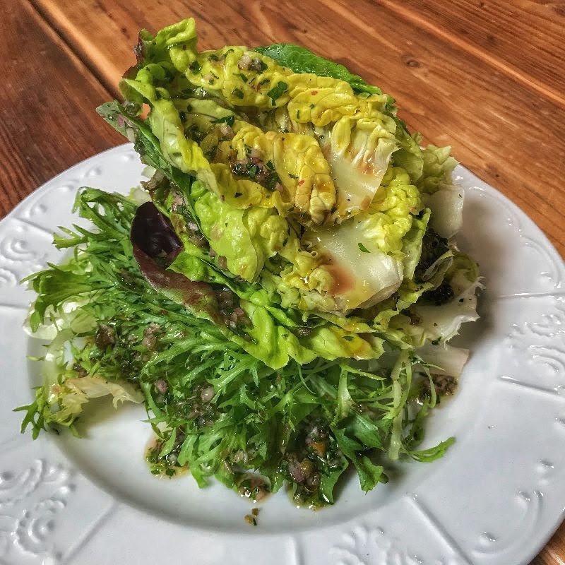 A plate with lettuce and greens on it.