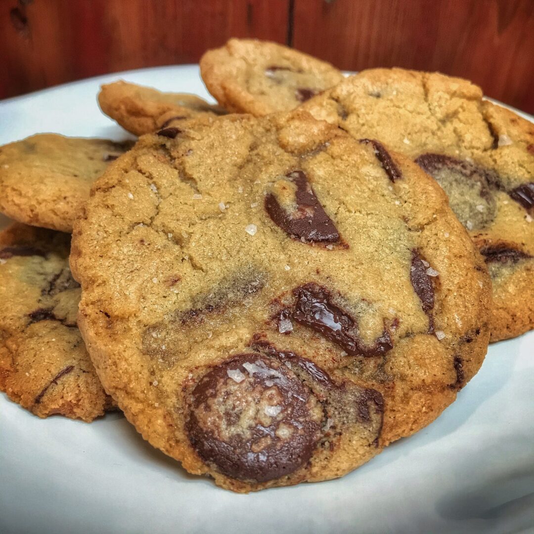 A plate of chocolate chip cookies on a wooden table.