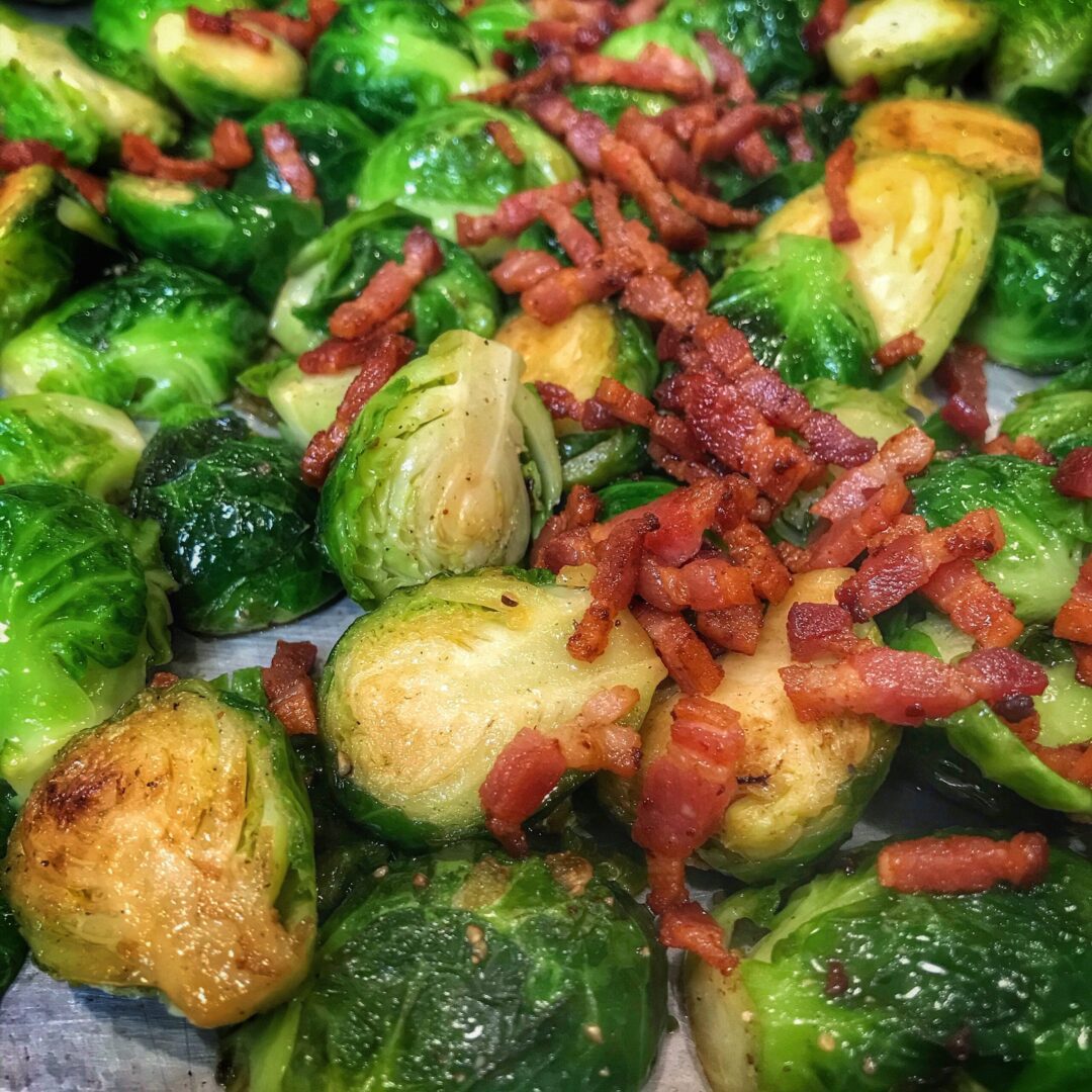 Brussels sprouts with bacon on a baking sheet.