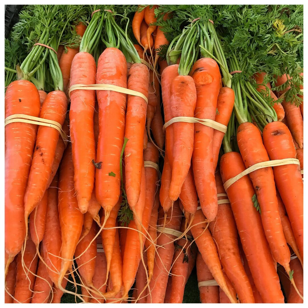 A bunch of carrots are sitting on a table.