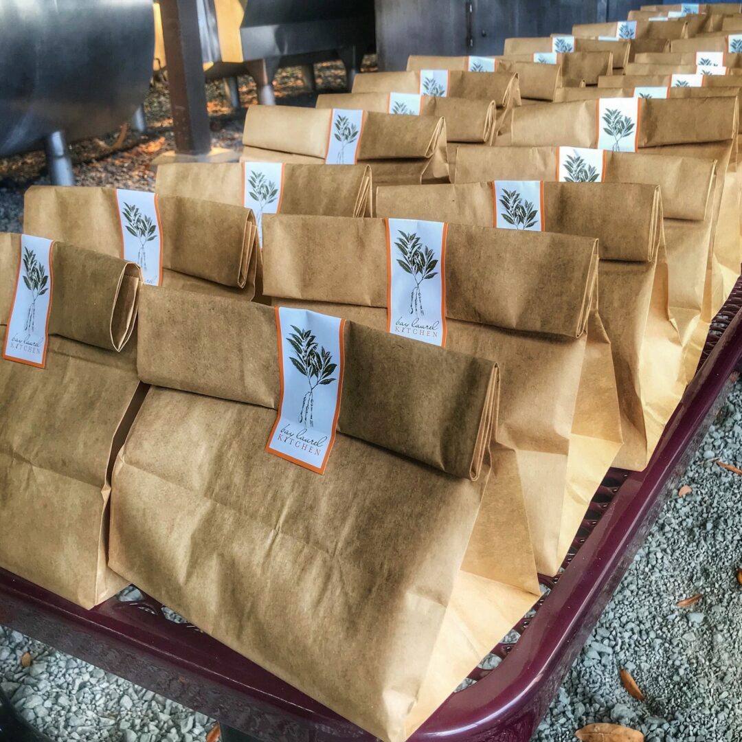 A line of brown paper bags on a conveyor belt.
