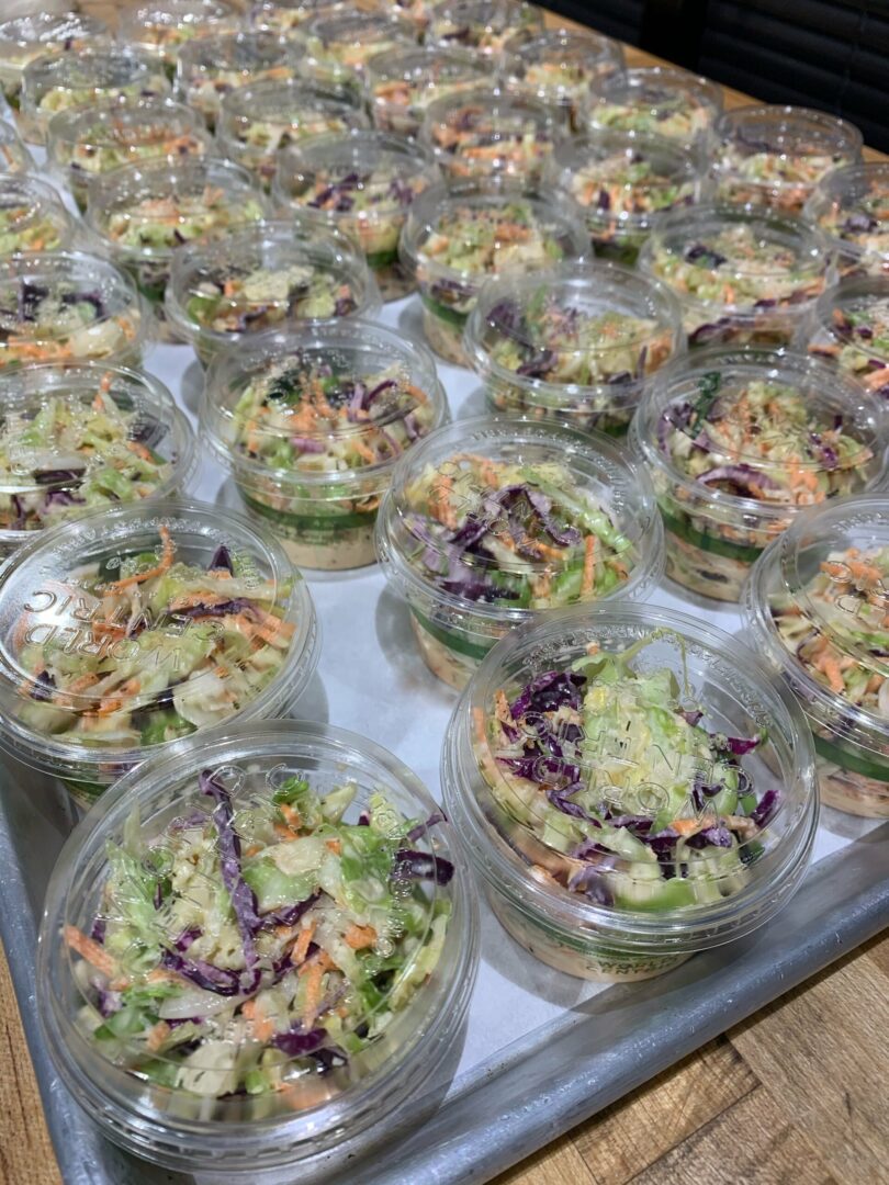 A tray of plastic containers filled with salads.