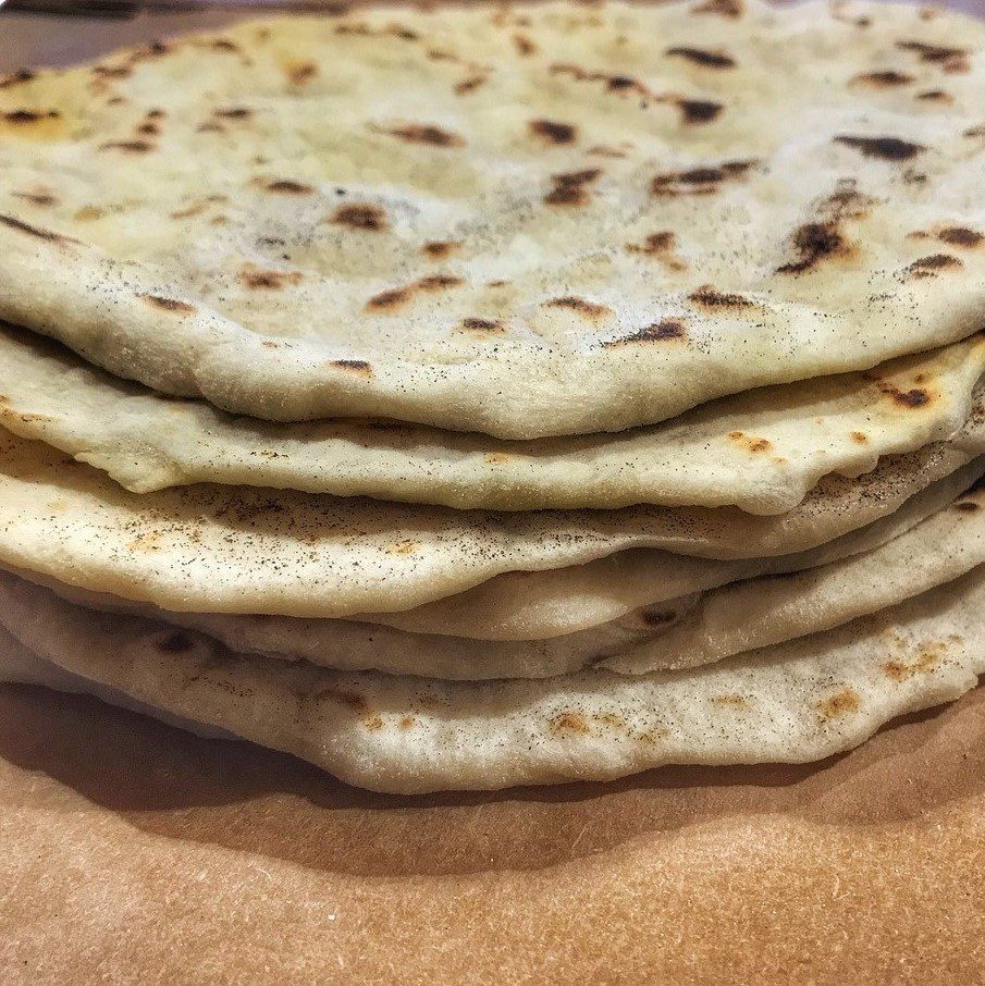 A stack of flatbreads sitting on top of a piece of paper.