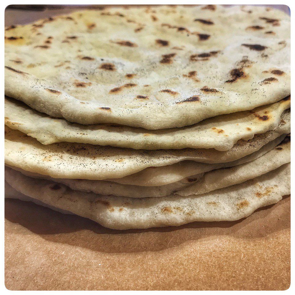 A stack of flatbreads sitting on top of a piece of paper.