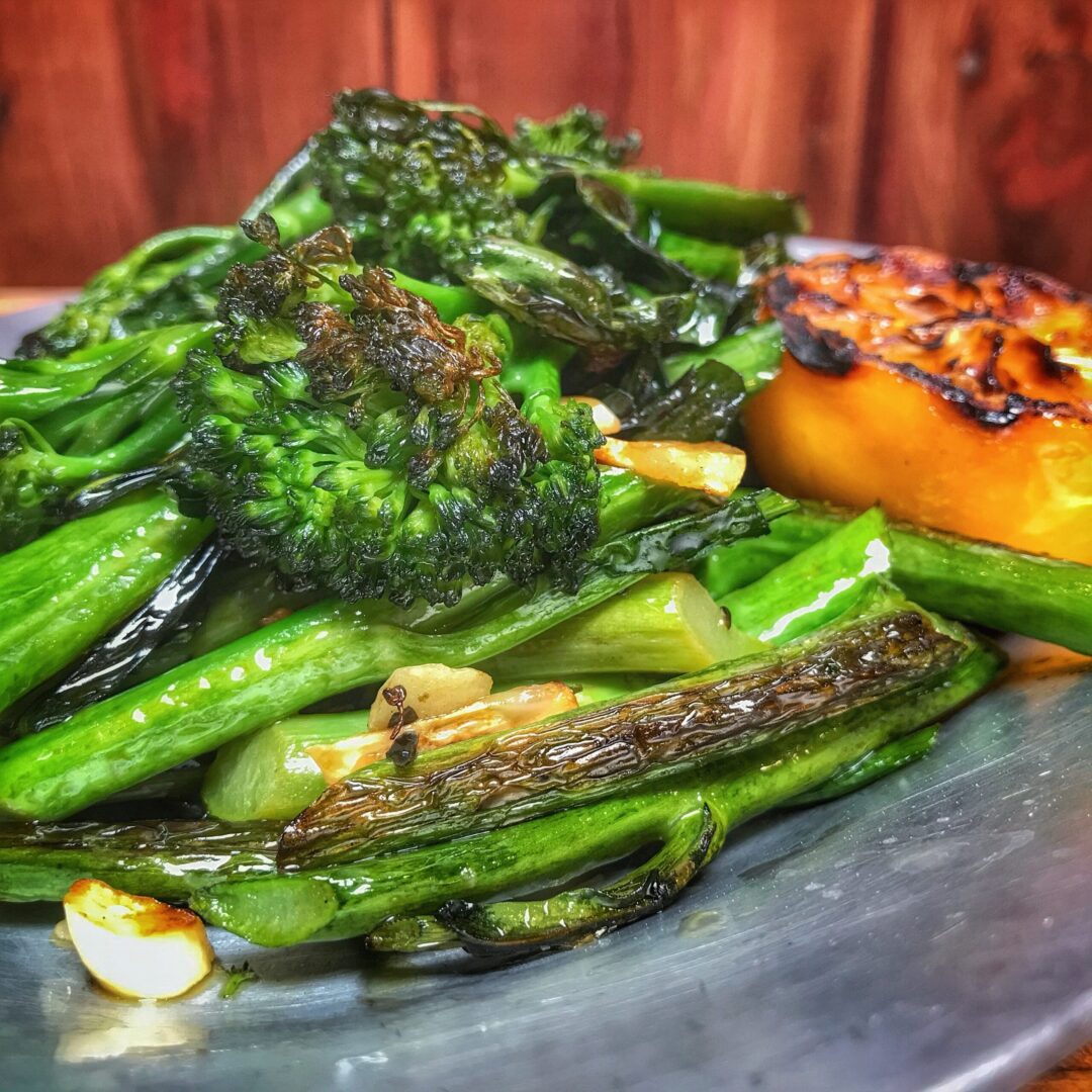 A plate with broccoli and grilled vegetables.
