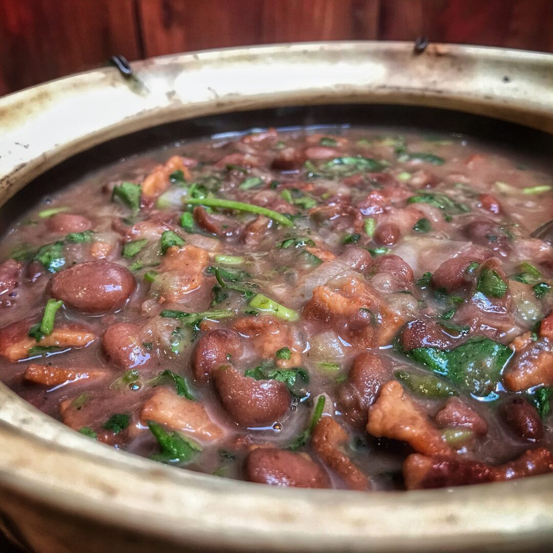A pot of beans in a wooden bowl.