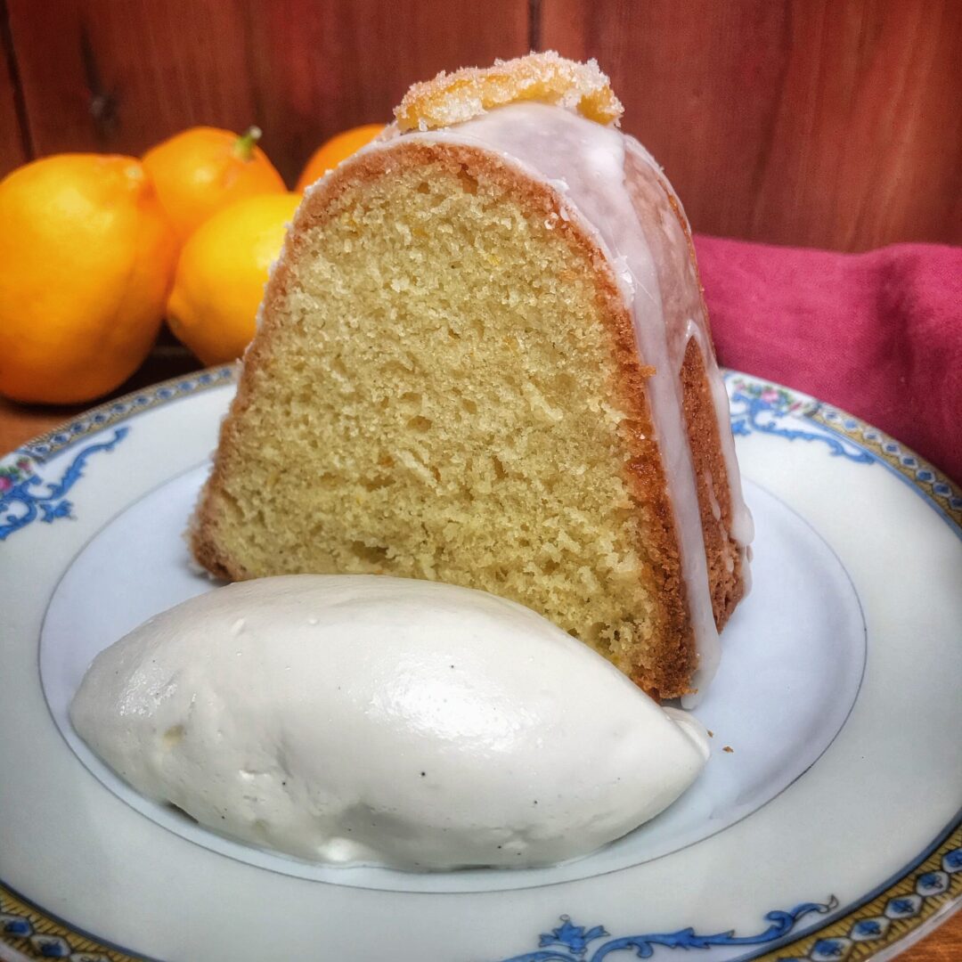 A bundt cake with ice cream and lemons on a plate.