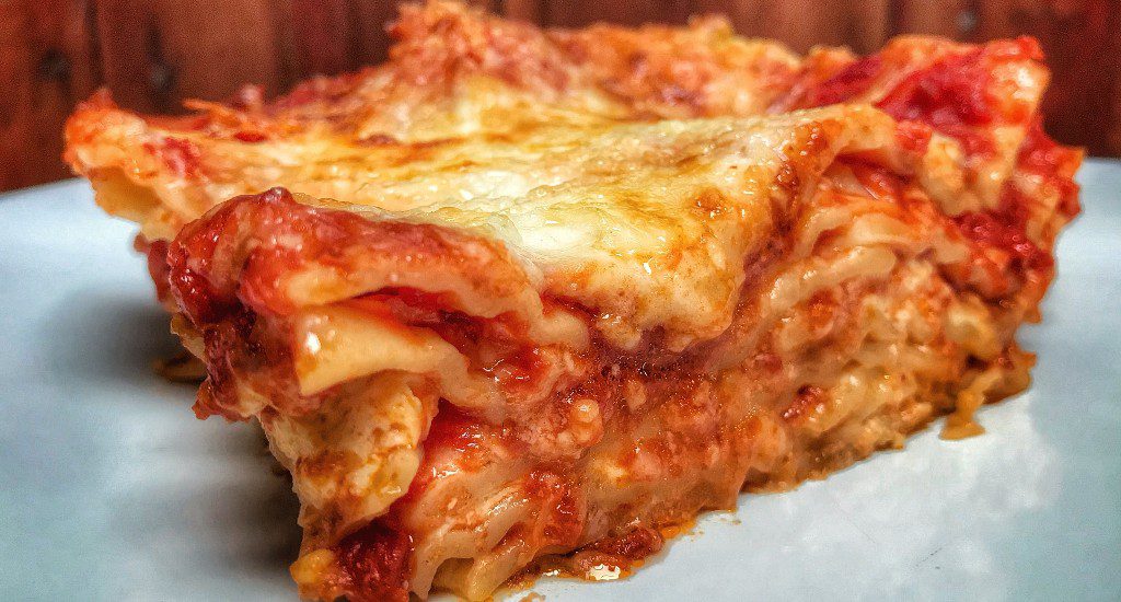 A slice of lasagna on a plate.