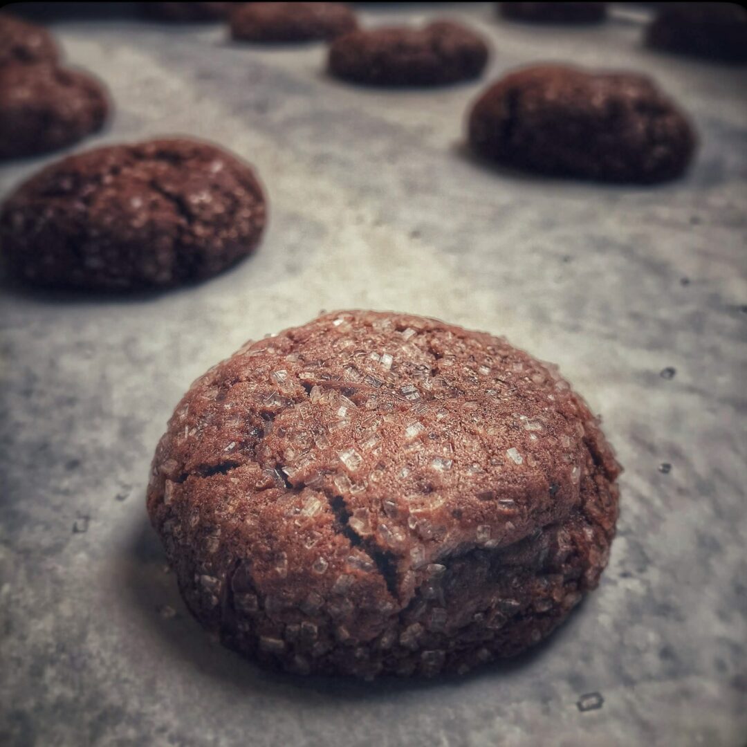 A group of chocolate cookies on a baking sheet.