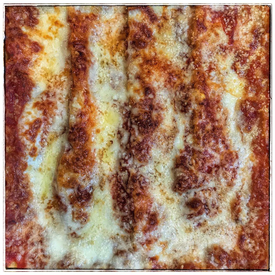 A close up of a lasagna with cheese on it.