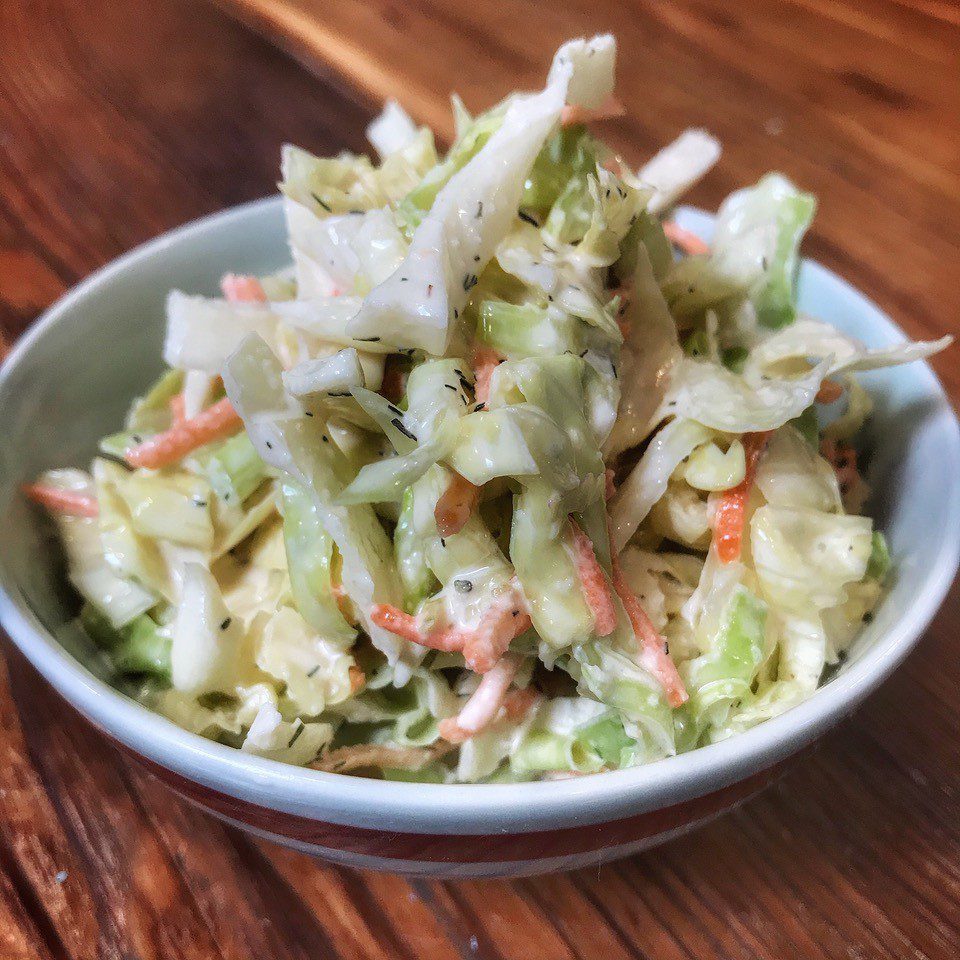 Coleslaw in a bowl on a wooden table.