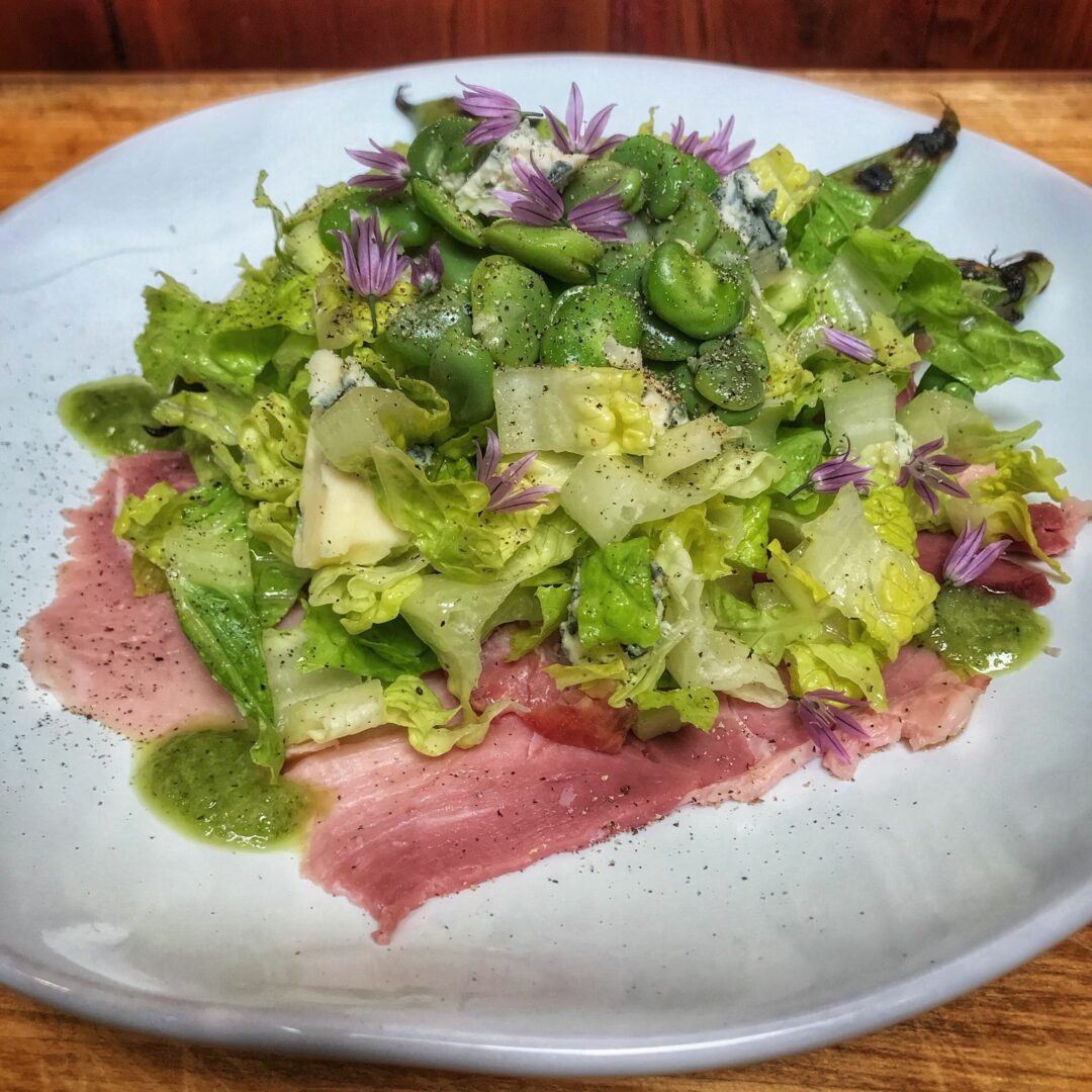 A plate with lettuce and ham on it.