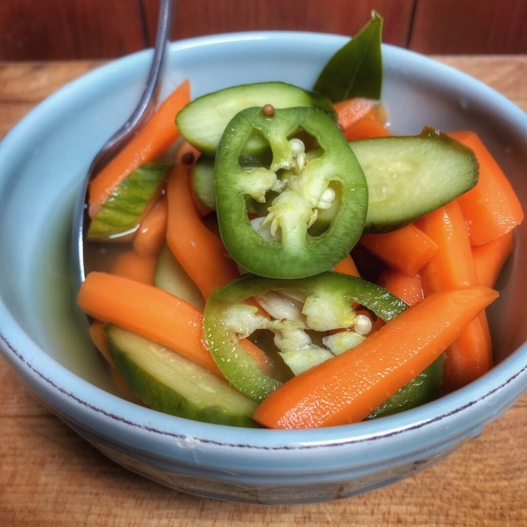 A blue bowl filled with carrots and peppers.