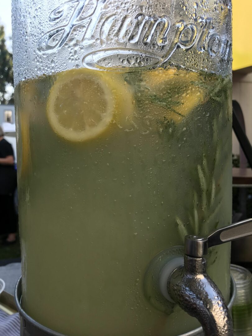 A pitcher of lemonade with lemon slices in it.