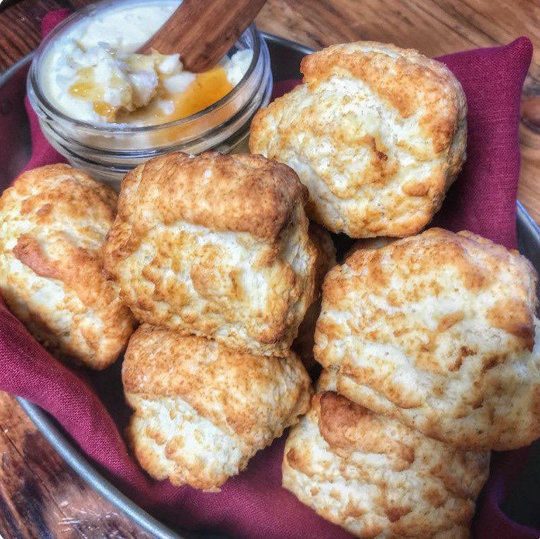 A plate of biscuits with a bowl of dipping sauce.