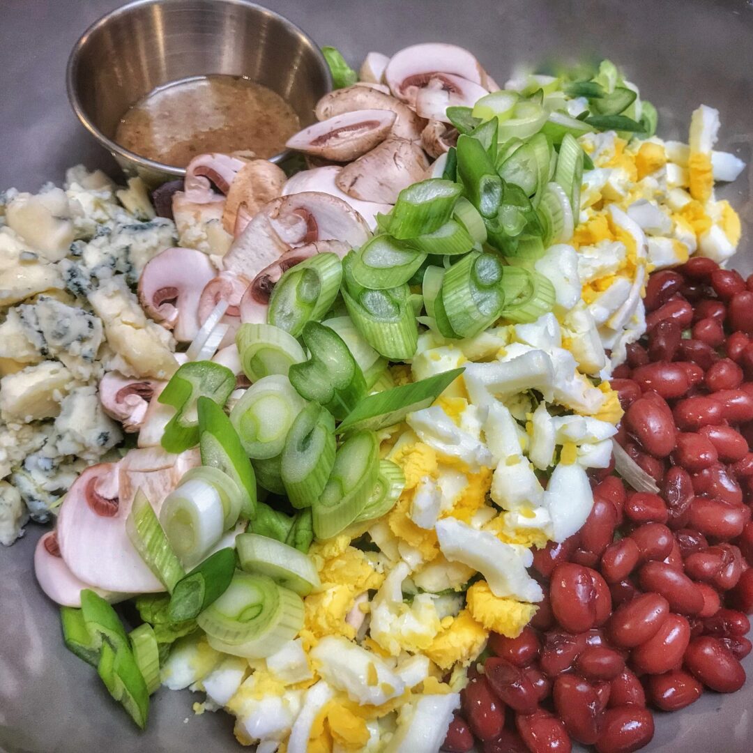 A bowl full of beans, onions, and other ingredients.