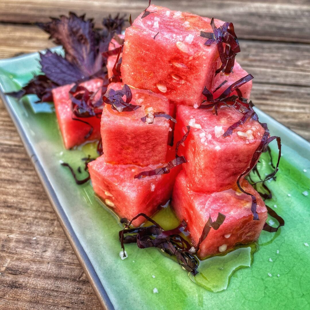 Watermelon cubes on a green plate.