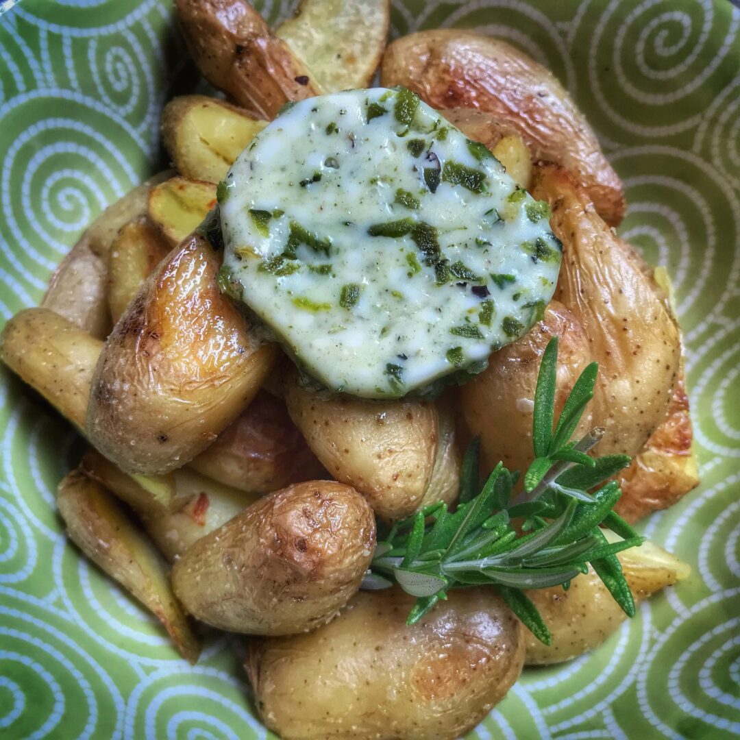 Roasted potatoes with sour cream and sprigs of rosemary.