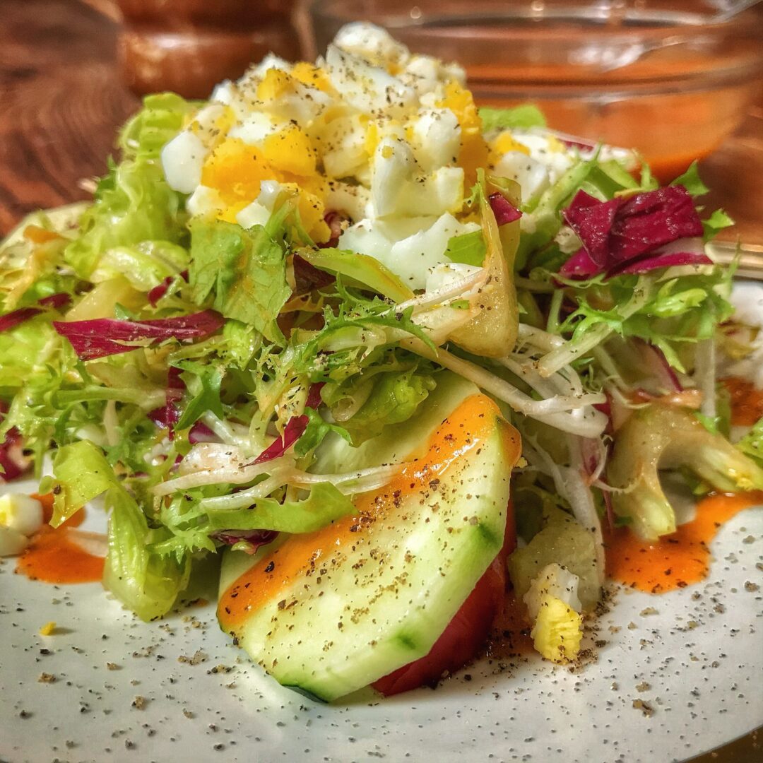 A salad with eggs and vegetables on a plate.