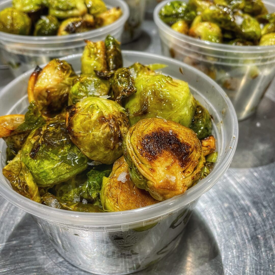 Brussels sprouts in plastic containers on a table.