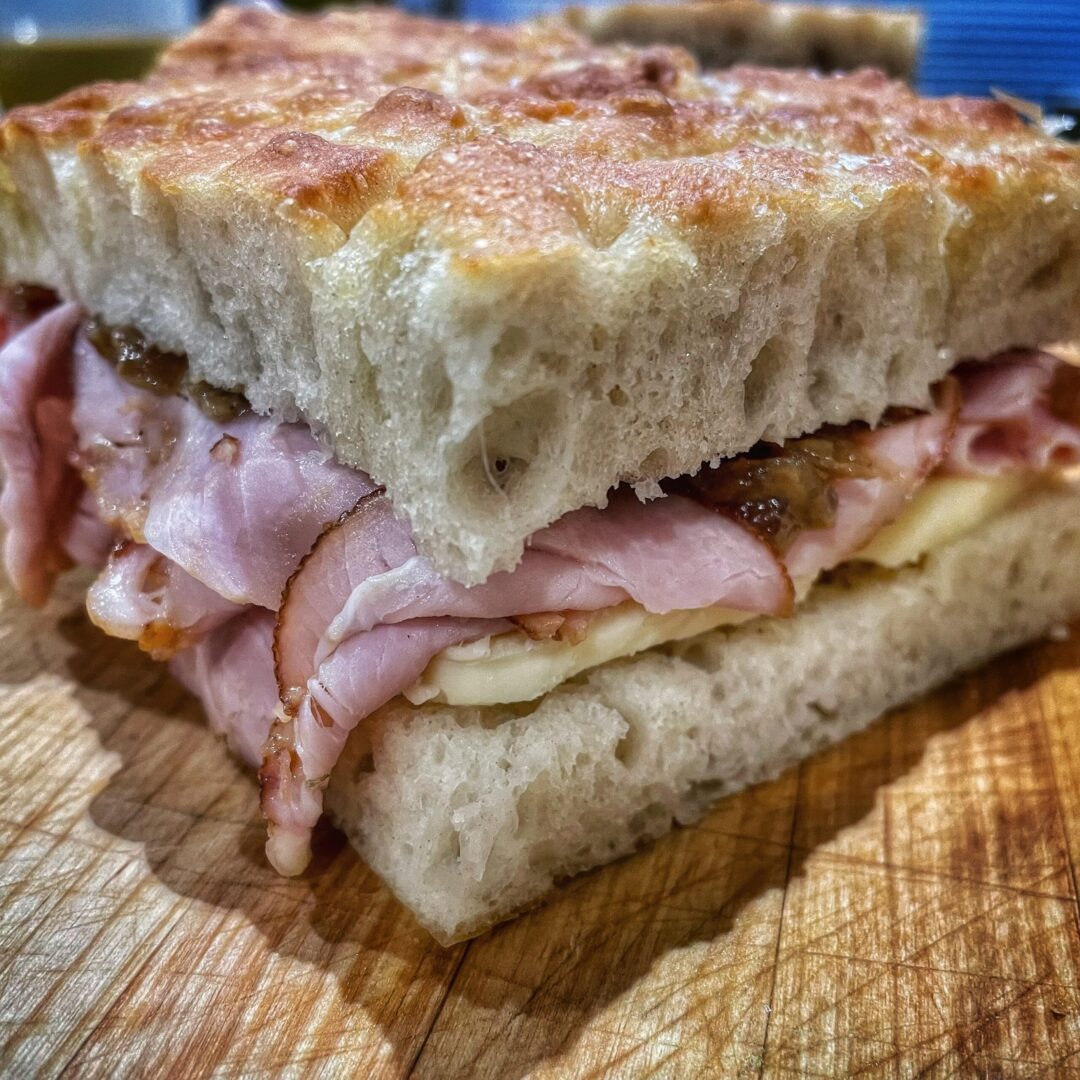 A sandwich with ham and cheese on a cutting board.