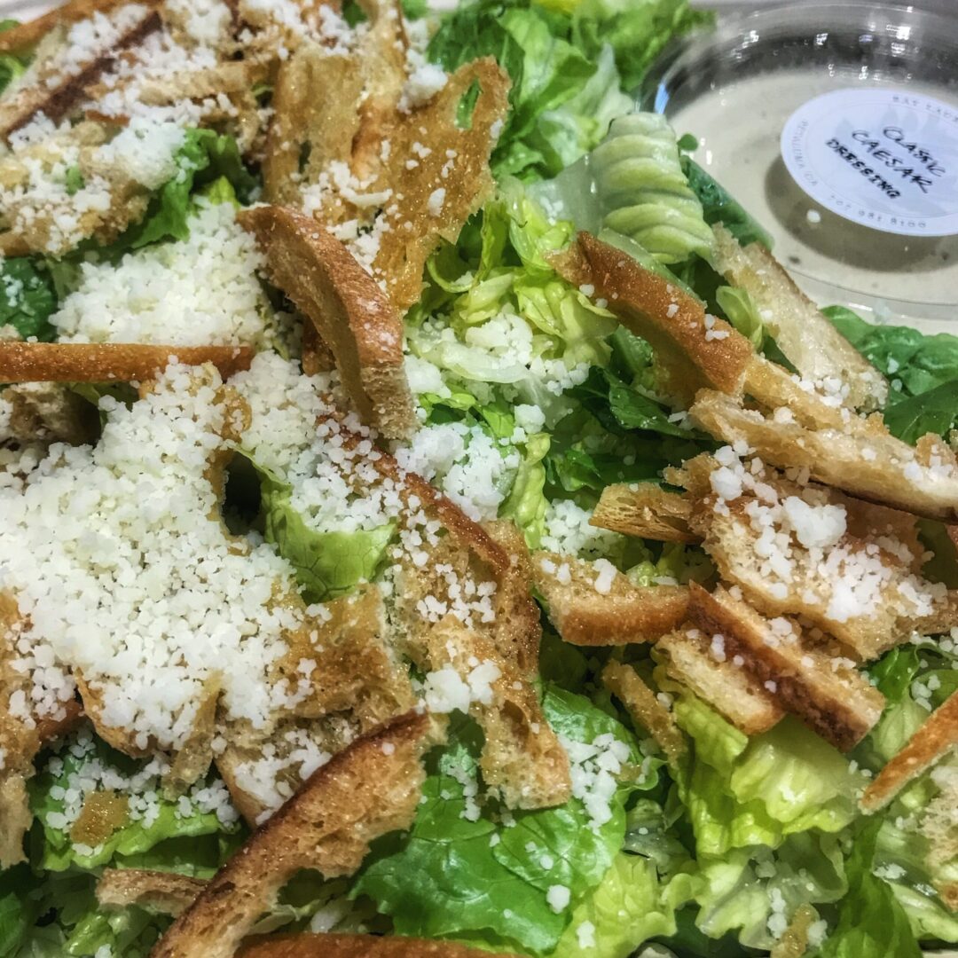 A salad with chicken, lettuce, and parmesan.